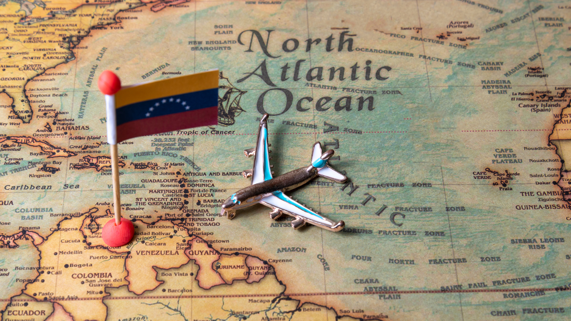 Map with a Venezuelan flag pin and an airplane, representing Rebuild Venezuela connecting international partners