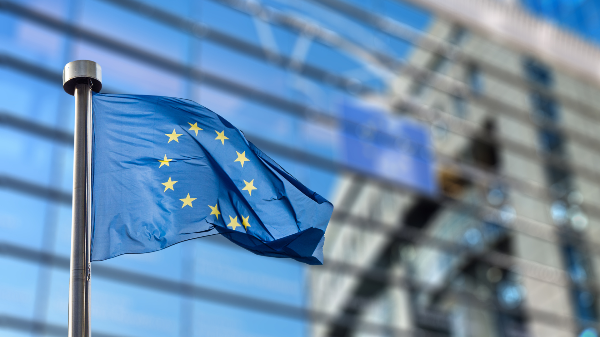 European Union flag in front of a modern glass building