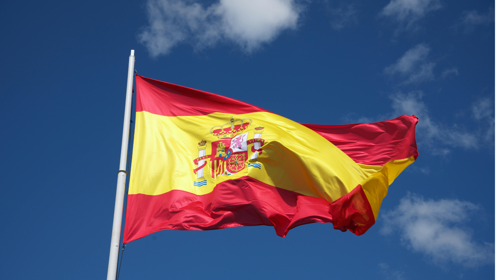 Spanish flag waving against a blue sky